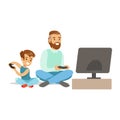 Father And Boy Sitting On The Floor With Joysticks,Part Of Happy Gamers Enjoying Playing Video Game, People Indoors