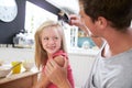 Father Brushing Daughter's Hair At Breakfast Table