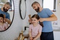 Father brushing his little daughter& x27;s hair in bathroom, morning routine concept. Royalty Free Stock Photo