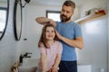 Father brushing his little daughter's hair in bathroom, morning routine concept. Royalty Free Stock Photo