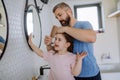 Father brushing his little daughter& x27;s hair in bathroom, morning routine concept. Royalty Free Stock Photo