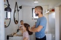 Father brushing his little daughter& x27;s hair in bathroom, morning routine concept. Royalty Free Stock Photo