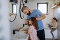 Father brushing his little daughter& x27;s hair in bathroom, morning routine concept. Royalty Free Stock Photo