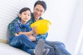 Father builder sitting his son holding engineer helmet for family career learning and future education concept