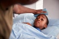 Father Caring For Sick Son Ill In Bed With Temperature Royalty Free Stock Photo