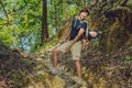 The father carries his son in a baby carrying is hiking in the forest. Tourist is carrying a child on his back in the nature of Vi Royalty Free Stock Photo