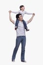 Father carrying daughter on his shoulders, studio shot