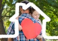 Father carrying girl holding heart shape