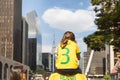 Father carrying his daughter on his shoulders, both wearing green and yellow T-shirts representing the colors of the Brazilian