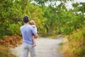 Father carrying his shild during walk in forest