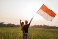 Father carrying little girl pride flapping Indonesian flag with happiness Royalty Free Stock Photo