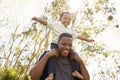 Father Carrying Son On Shoulders As They Walk In Park Royalty Free Stock Photo