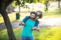 Father carrying son on shoulders outdoors. Portrait of a young dad and his child in the park. Royalty Free Stock Photo