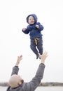 Father catching his baby son. Cute infant boy laughing and smiling. Outdoor shot. Family playtime Royalty Free Stock Photo