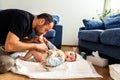 Father changing his baby`s diaper while caressing him affectionately Royalty Free Stock Photo