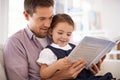 Father, child with book for reading and knowledge, happy with bonding at home and storytelling for education. Man, young Royalty Free Stock Photo