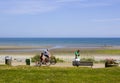 A father and child cycling along the new promenade at Newcastle County Down in Northern ireland on a bright and warm sunny day