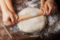 Father and child hands making the dough with flour, rolling pin and wheat ears on rustic wooden table top view. Royalty Free Stock Photo