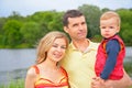 Father with child on hands and mother outdoors