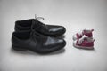 Father with Child Metaphor, baby and adult shoes