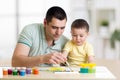 Father and child paint together. Dad teaches son how to paint correct and beautiful on paper. Family creativity and