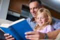 Father, child and reading a book for education at home, story and fantasy fiction for homeschooling. Daddy, daughter and