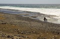A father and child relax and play together on the pebble beach at Playa Las Americas in Teneriffe in the Spanish Canary Islands
