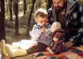 Cute boy with nose wiper near autumn tree. Father and child son in autumn park having fun and laughing. Happy family