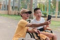 Father and child on wheelchair using some mats phone Royalty Free Stock Photo