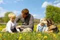 Father, Children, and Dog Relaxing in Flower Meadow Royalty Free Stock Photo