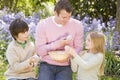 Father and children on Easter looking for eggs Royalty Free Stock Photo