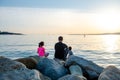 Father with children on a fishing trip by the sea. A boy and a girl with their father have fun fishing on the beach or by the sea.