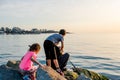 Father with children on a fishing trip by the sea. A boy and a girl with their father have fun fishing on the beach or by the sea. Royalty Free Stock Photo