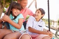 Father And Children Having Fun On Swing In Playground Royalty Free Stock Photo