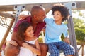 Father With Children On Playground Climbing Frame