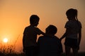 Father and children playing in the park at the sunset time. Royalty Free Stock Photo