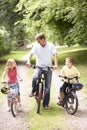 Father and children riding bikes in countryside