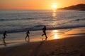 Father and children running on the beach during sunset, Praia da Luz, Portugal Royalty Free Stock Photo