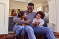 Father And Children Sitting On Step At Home Putting On Boots Before Going On Family Walk Royalty Free Stock Photo