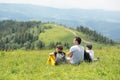 Father and children are sitting on the top of the mountain and looking into the distance Royalty Free Stock Photo