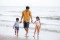 Father And Children walking On Beach Holiday . two kids one dad