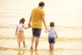 Father And Children walking into the Beach Holiday . two kids one dad . rear back view