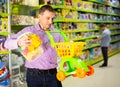 Father choosing playthings in toy store