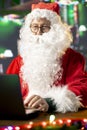 Father Christmas is navigating the web checking on children wish lists Royalty Free Stock Photo