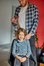 Father combing, brushing his daughter& x27;s hair at home, child making faces about hair pulling Royalty Free Stock Photo