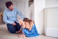 Father Comforting Unhappy Daughter Sitting On Floor Holding Teddy Bear