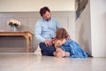 Father Comforting Unhappy Daughter Sitting On Floor Holding Teddy Bear