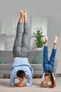 father copy imitate active child girl doing gymnastic handstand exercise