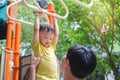 Father and Cute little Asian 2 - 3 years old toddler baby boy child having fun exercising outdoor and dad help catch up on Monkey Royalty Free Stock Photo