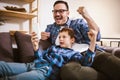 Father and cute little son using phone apps together, watching cartoons or video, playing game Royalty Free Stock Photo